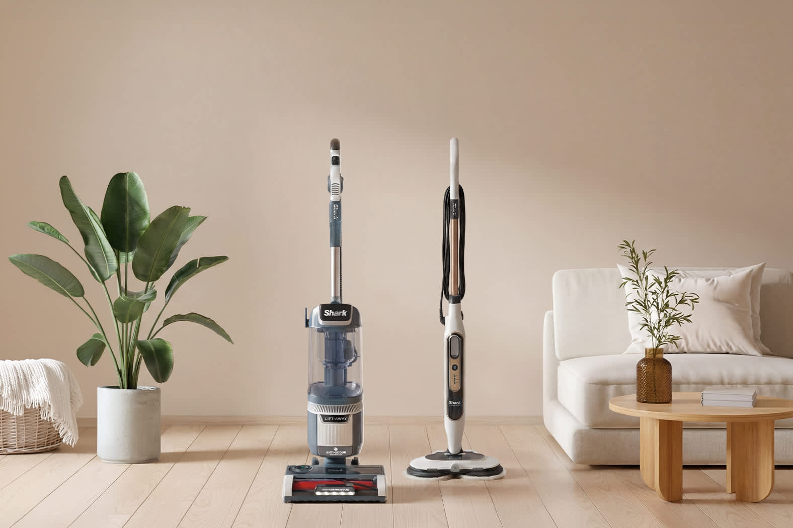 Twee reinigingsmachines en een mop naast planten en een witte bank in een woonkamer