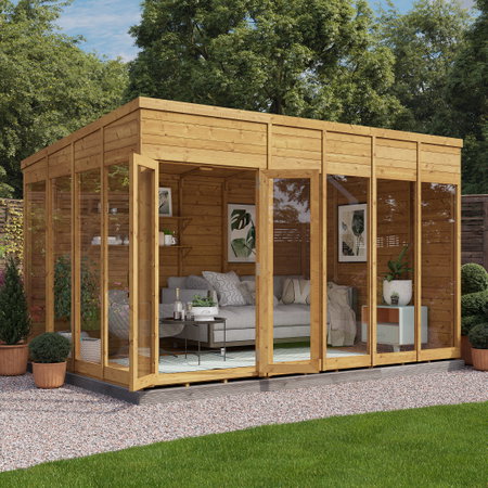 Grote houten tuinkamer met glazen schuifdeuren en interieur ingericht als lounge- en werkruimte.
